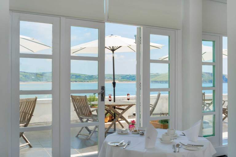 View through the Art Deco windows at the Burgh Island Hotel, overlooking Bigbury and Bantham beaches.