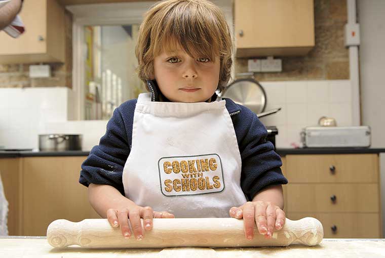 Child is getting ready to cook at school