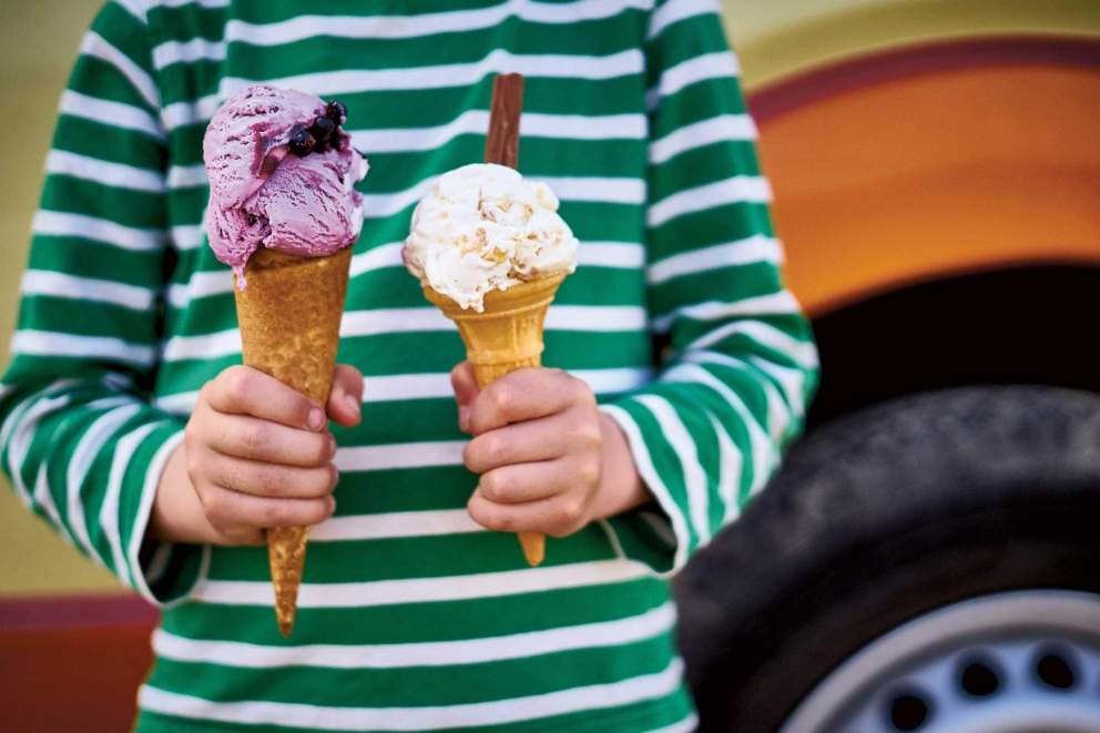 Child with ice creams in front of ice cream van