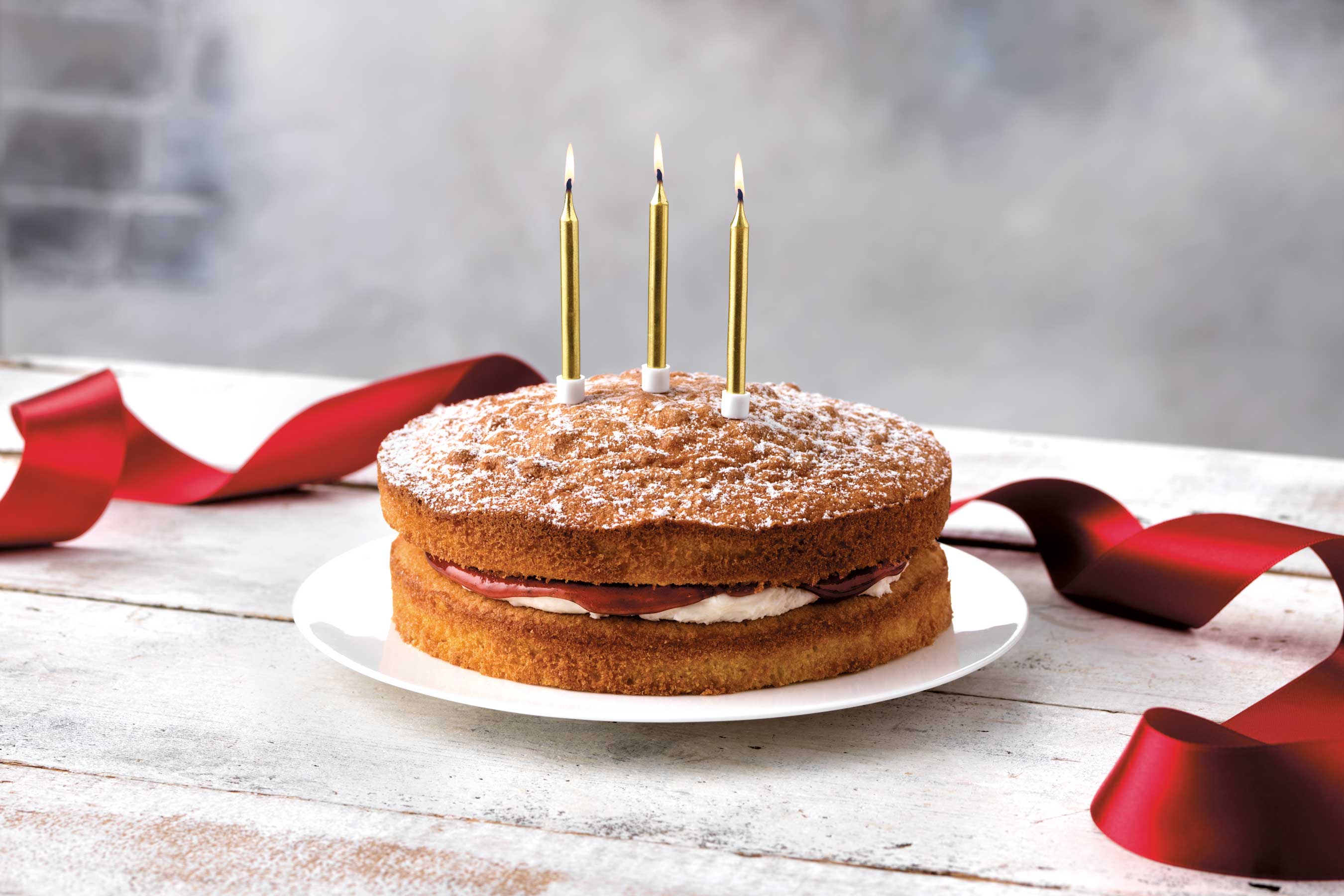 Victoria sponge with lit birthday candles